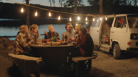 Freunde-Unterhalten-Sich-Beim-Abendessen-Auf-Dem-Campingplatz